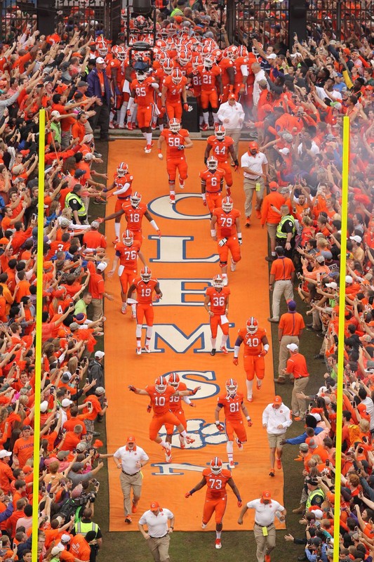 Clemson players running down the hill after touching Howard's Rock