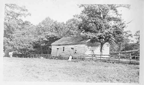 An unidentified woman tends the garden in front of the Tusculum Academy building.