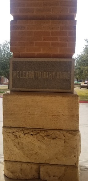 The cornerstone, laid on January 10, 1903. The motto “We learn to do by doing” was suggested by founding member of the Board of Regents, Helen Stoddard.