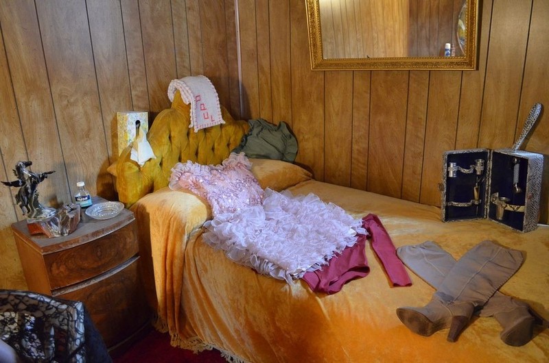 Interior of one of the rooms, complete with an outfit and a scarf that was hand-knitted by one of the girls for "Paul", a regular at the Oasis