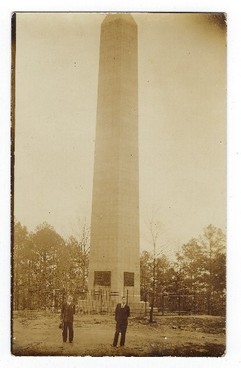 An early picture of the monument with a fence surrounding it to keep vandals from harming it.  The plaques are now added. 