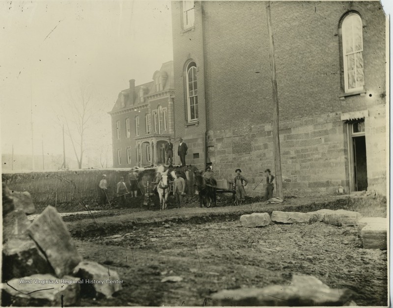 Men work to excavate an area for the foundation of the first addition to Woodburn Hall, the north wing. Photo taken ca. 1900