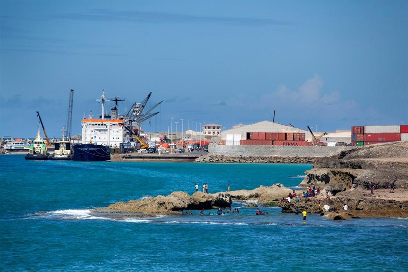 This is a fairly recent photo of the port. People are swimming near the rocks and they are fairly close to a fully functioning port. This photo does a good job displaying both of the uses of the Port. Not only is it utilized for exporting and importi