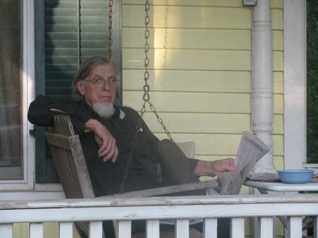 Dr. Orme on his front porch reading the newspaper. 
