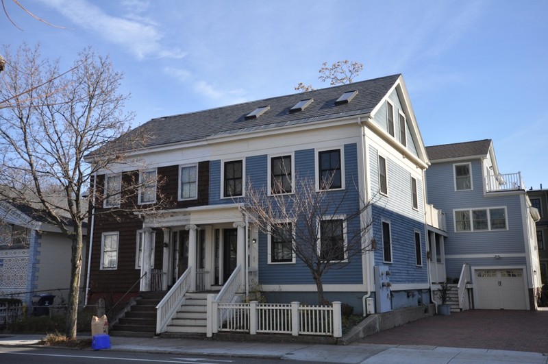 Color photo of a blue, wood-panelled house