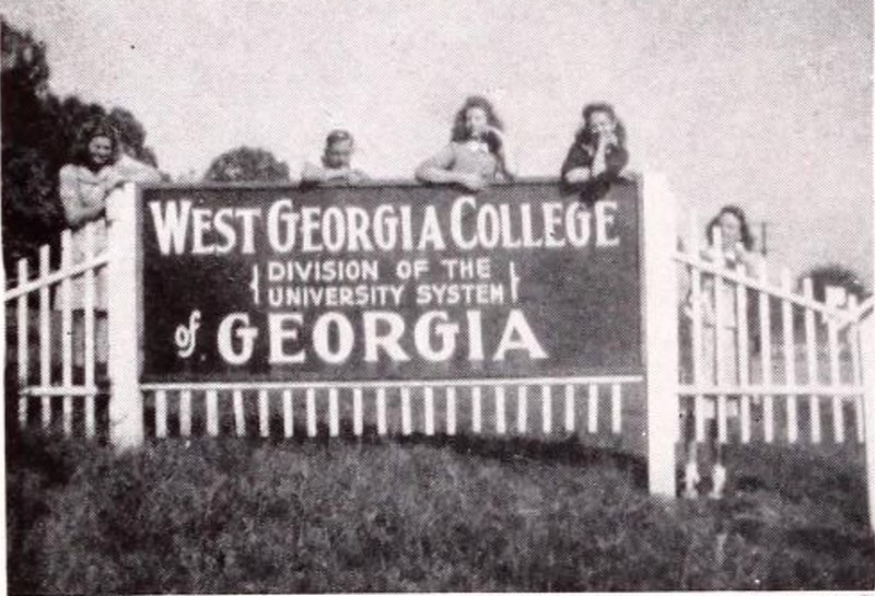 Sign, students, grass, sky