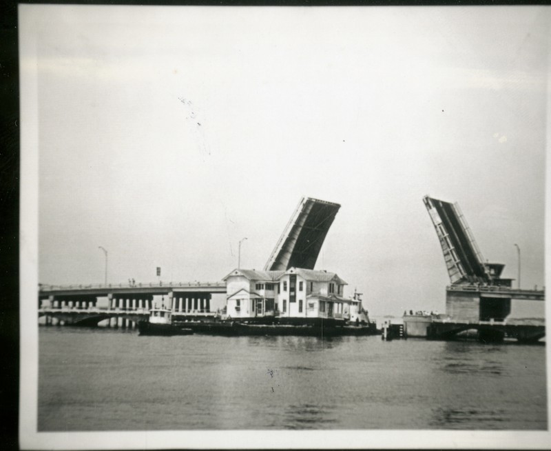 Moving the House of Seven Gables to Heritage Village underneath the Belleair Bridge, 1976.