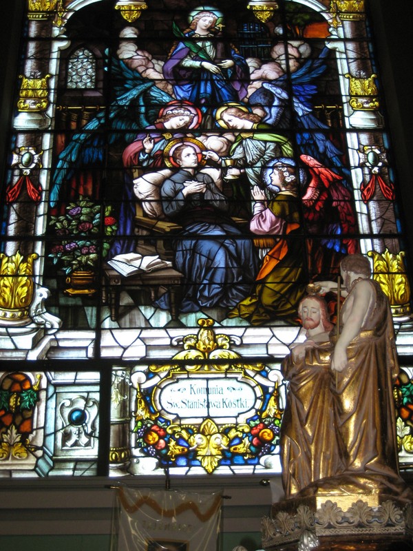 Stained glass window depicting St Stanislaus Kostka with baptismal font in foreground