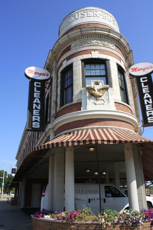 Kickapoo Building in Peoria with view of Anheuser-Busch name and logo amidst signs for the cleaners. 