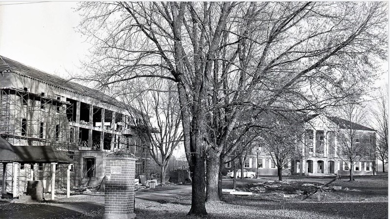 McCuskey Hall under construction. Notice the "classic car" on the sidewalk and  the old Spring House in the bottom left corner.