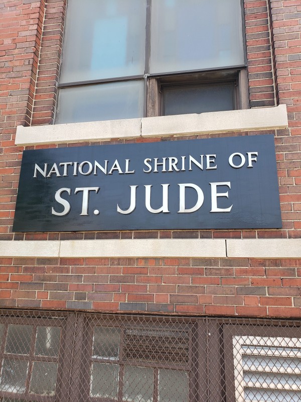 On the left-hand side of the building, a sign indicating the church's historic role as a center of devotion to Saint Jude is prominent.