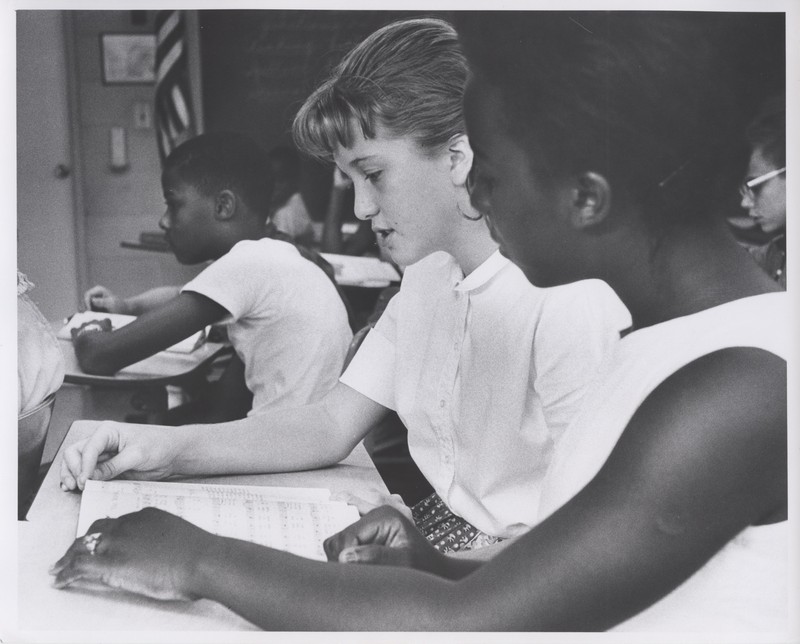 Classmates share a songbook at St. Joseph's School after integration. 