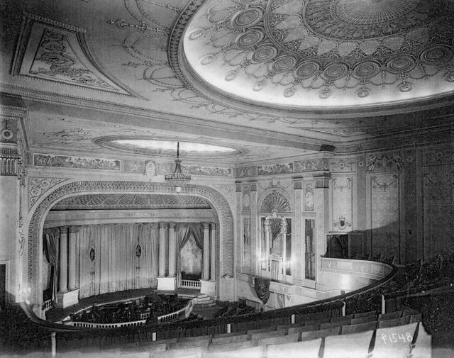 1921 photo with view of Madison Theater with its ornate details, proscenium, main curtain, side stages, and orchestra pit.