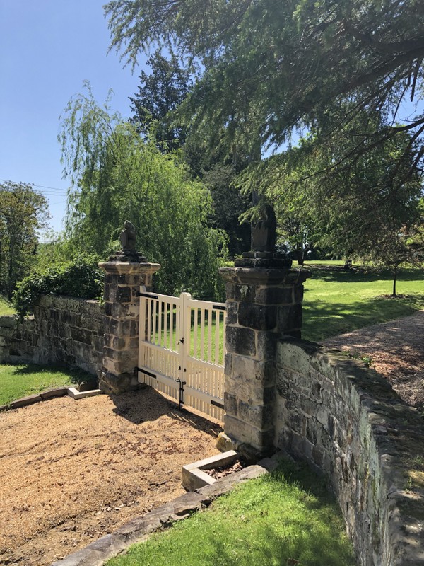 Gate with lion-topped posts and stone wall