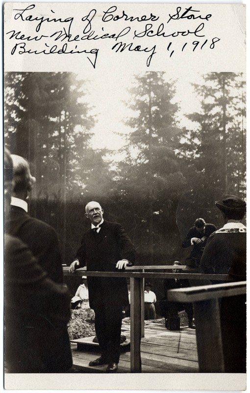 Black and white photograph of the University of Oregon Medical School, Medical Science Building (Mackenzie Hall) cornerstone laying ceremony. Photograph contains handwriting in the upper margin: "Laying of cornerstone for the new medical school building, May 1, 1918."