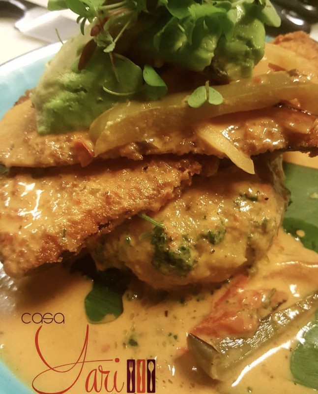 Vegan Honduran Machuca made from mashed sweet and green plantains and topped with avocado, micro greens, and a crispy eggplant smothered in coconut creole sauce. The regular Honduran Machuca is made with their catch of the day and shrimp.