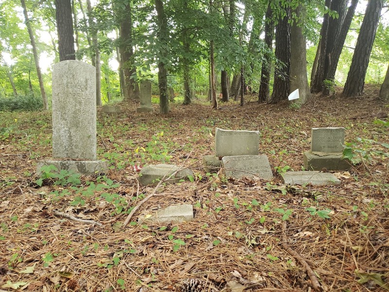 Headstones in the Friendship Baptist Church "Old Cemetery," some showing signs of vandalism.
