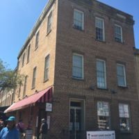 This is a picture of the original Montmollin Building. The middle window of the top floor is said to be where the actual auction block was located and the two side windows are where the women would change their clothes to be sold into the slave trade.