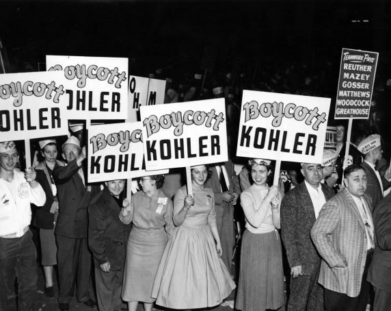 Women hold signs in support of the 1954 Kohler strike