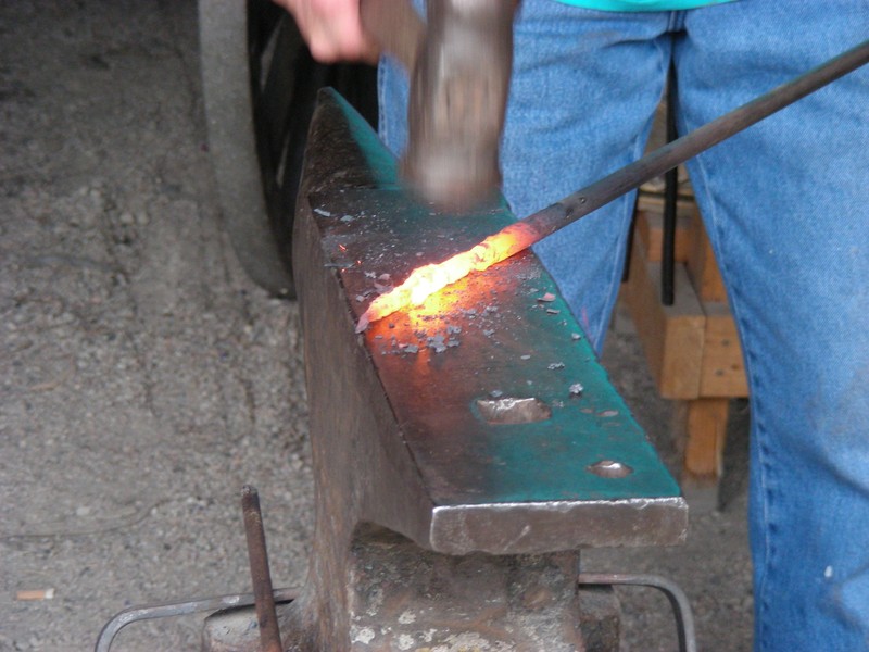 One of Four Mile's Blacksmiths hammers a piece of hot steel