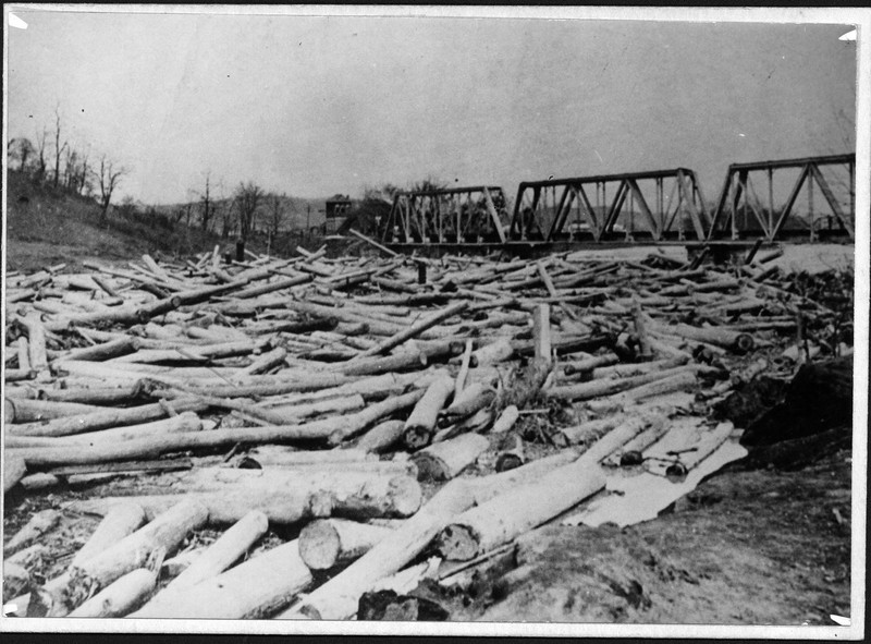 Floating logs jammed up against the bridge. Some claimed that the bridge had been weakened due to rising waters and the supports being rammed by logs. Image courtesy of Marshall University Special Collections. 