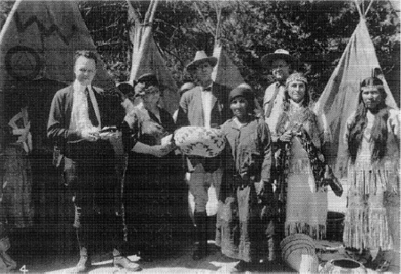 The winner of a basket weaving competition poses with visitors and park officials.
