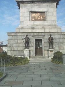 The Eakins bronze relief plaque in this front view depicts the opening of the Battle of Trenton. The central entrance door is flanked by a pair of bronze, full-length figures of Continental soldiers.