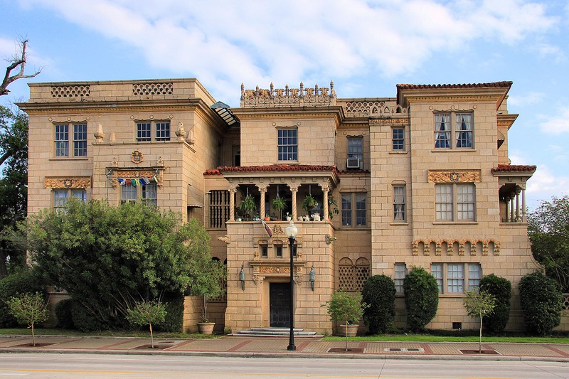 The apartment building is three stories tall and features an impressive facade.