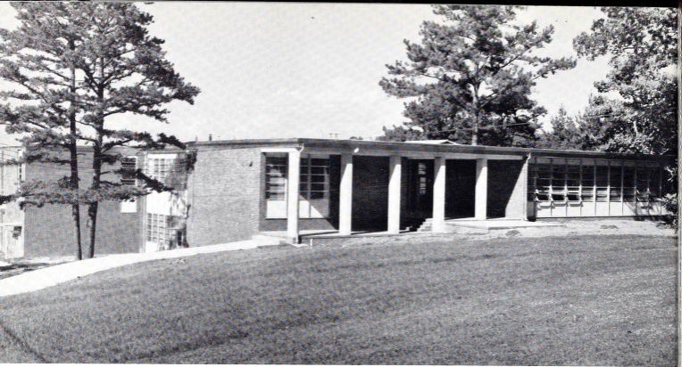 Black and white photo of building, sky, tree, and grass