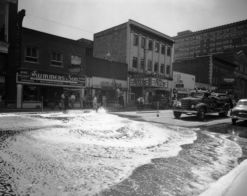 Water from a fire hydrant floods the street during the August 1952 fire