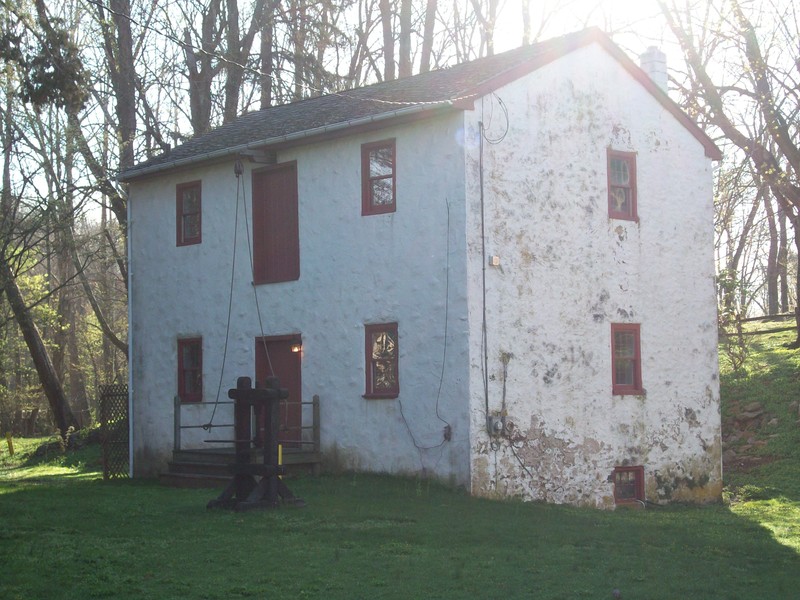 Image of 2-story stuccoed building with a pulley system above the central doors.