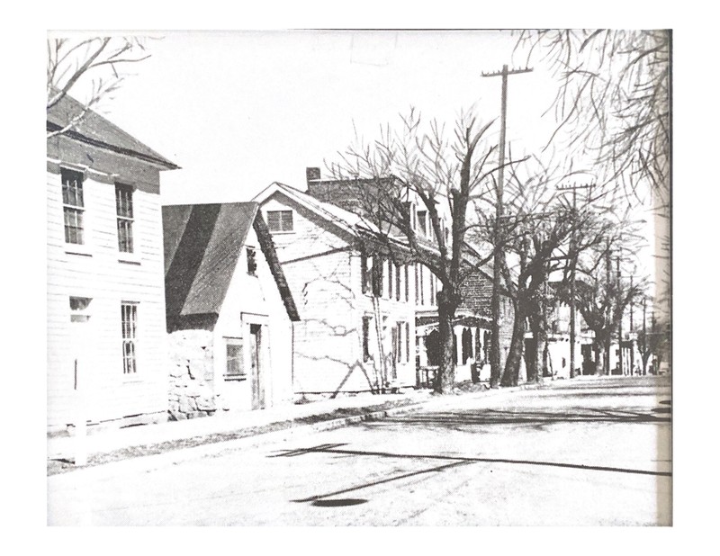 Old photo of Main Street, the jail is featured on the left and is the second building. 