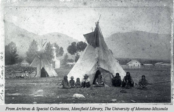 A group of Native Americans sitting in front of the original mission circa 1880s