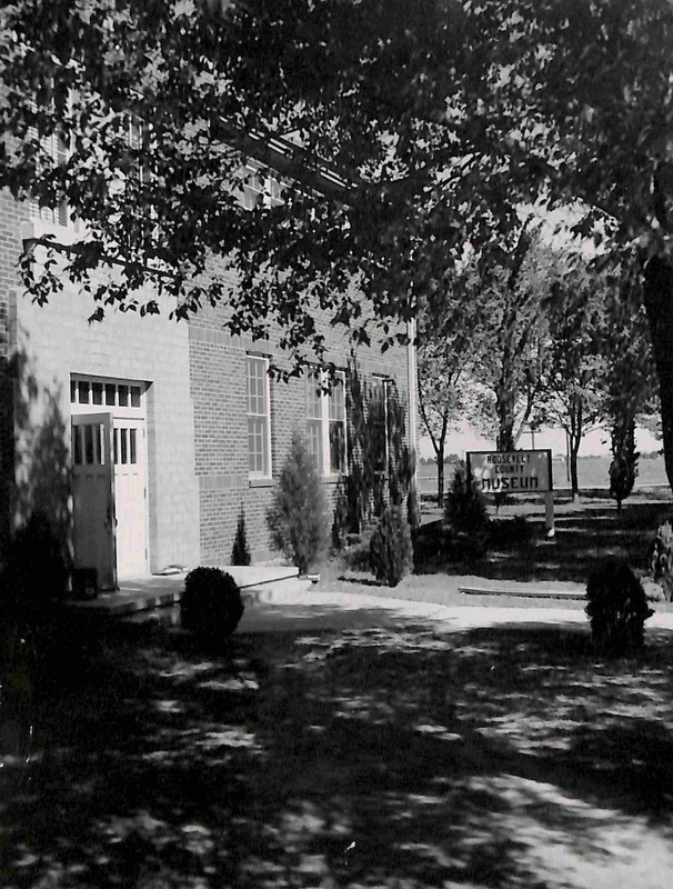 Photo of the Roosevelt County Museum. Bushes and trees also pictured.