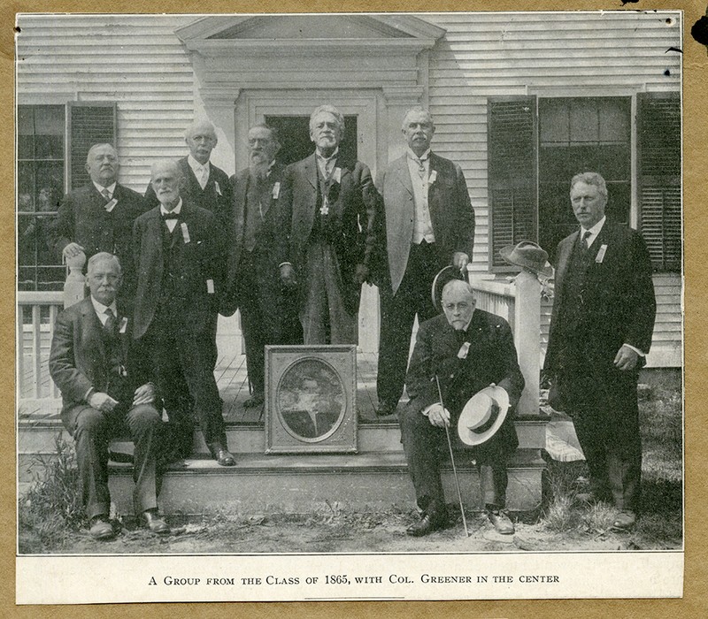 A group from the class of 1865 with a framed photograph of Richard Greener in the center, 1915