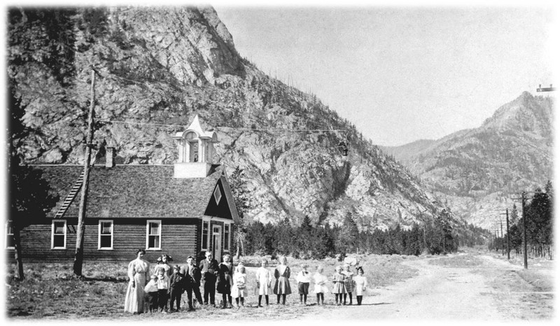 The Frisco Schoolhouse with Miss Lynch, teacher, and a group of 15 children. Note the telephone poles and the Victorian era cupola. Circa 1910