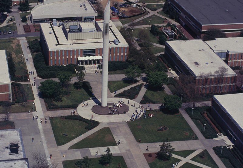 Aerial view of Belk Bell Tower and the surrounding quad, circa 1970s-1980s. Students can be seen around the base of the tower, and buildings in the background.