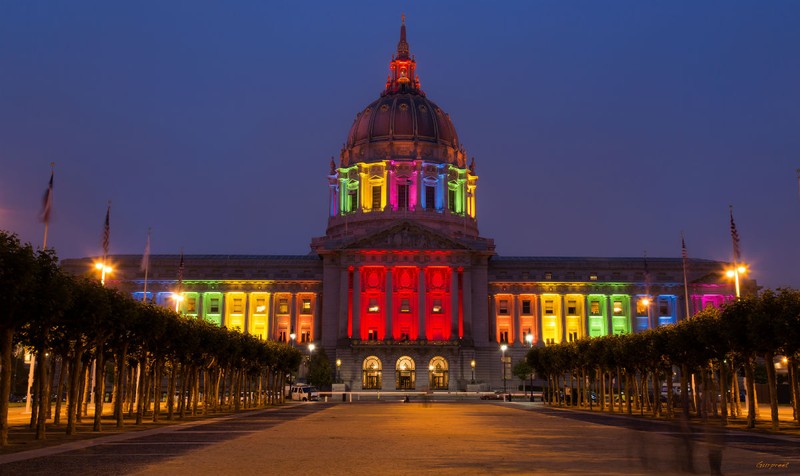 City Hall lit with the colors of the rainbow flag for Pride month