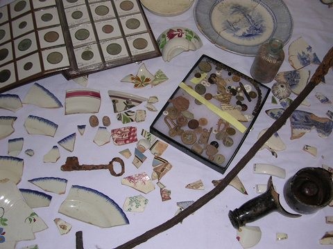 Some of the artifacts found during demolition/rebuild of McAtee's Tavern. Note the book of coins in the upper left corner of the photo. Most of these dated from the operation of the tavern, a finding consistent with having paying customers frequent the building.