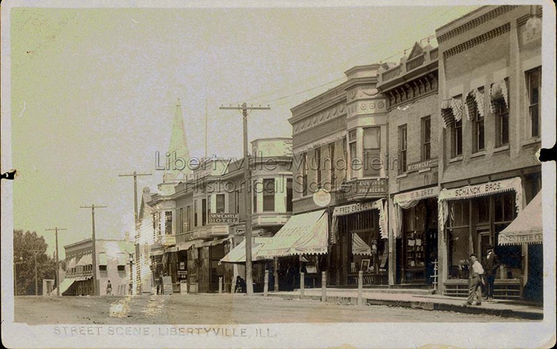 Looking north on Milwaukee Avenue, before 1913. Storefront canopies for E.B. Eger and Schanck Bros. visible