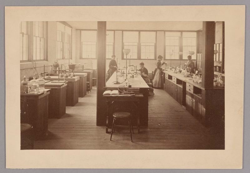 Black & White Photo, women in long dresses (19th century) working at chemistry lab benches