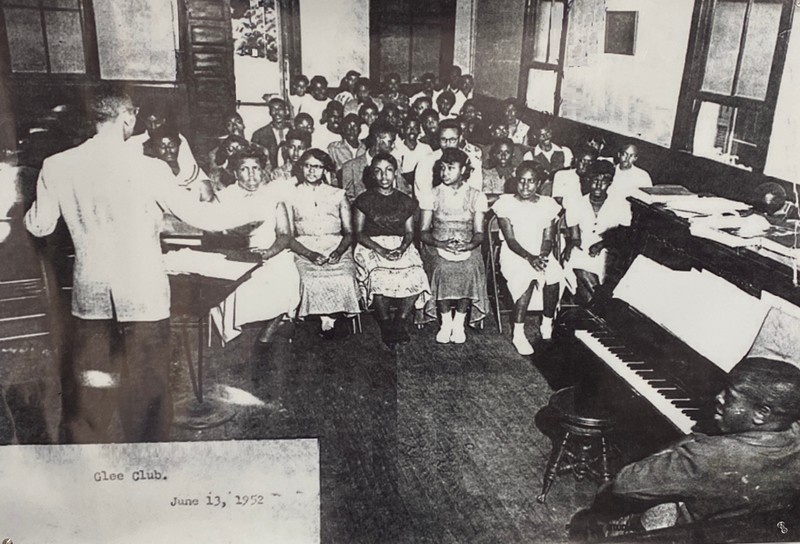 Pictured is a Glee club practice in the nearby church. The church provided extra space for activities when the school began to experience over crowding.