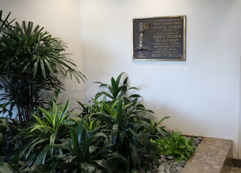 A picture of the Beacon of Health Plaque with plants in the foreground