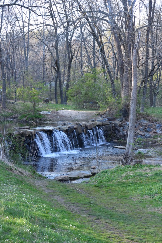 Water flowing over stone spillway of mill dam