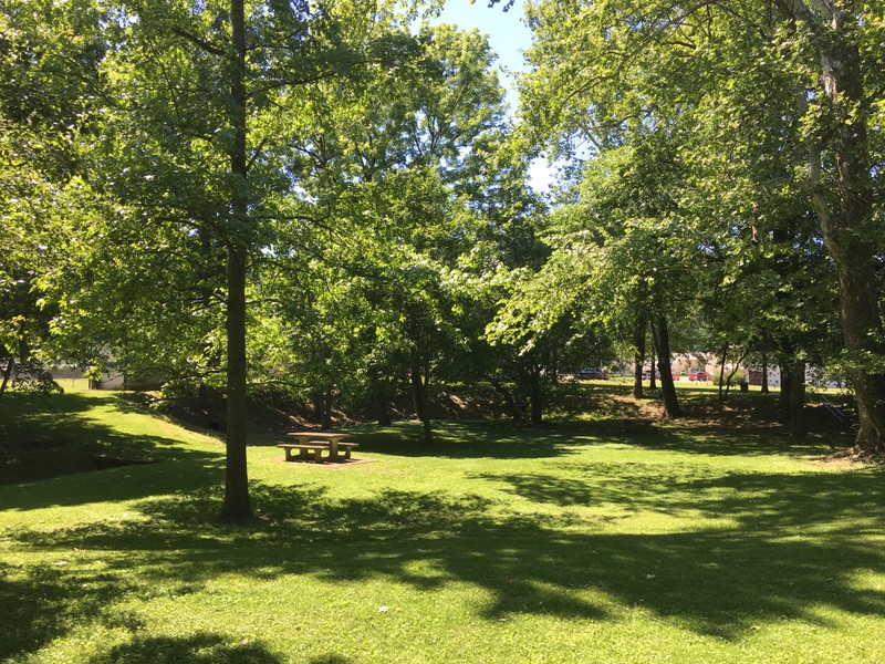 The park includes a walking trail, picnic tables, and green space for recreational activities.