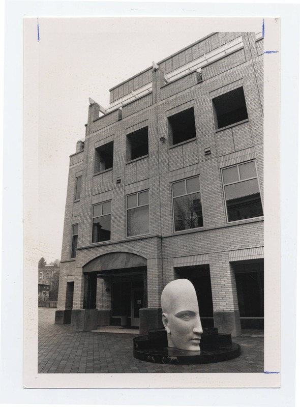 Black and white photograph of the Vita Mensae sculpture, depicting half a human head, in front of the Center for Research on Occupational and Environmental Toxicology.
