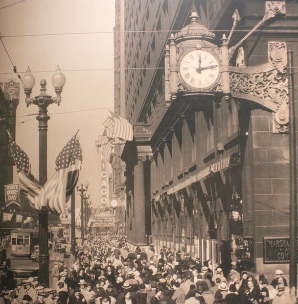 Pedestrians walk past and gather under one of the store's iconic clocks