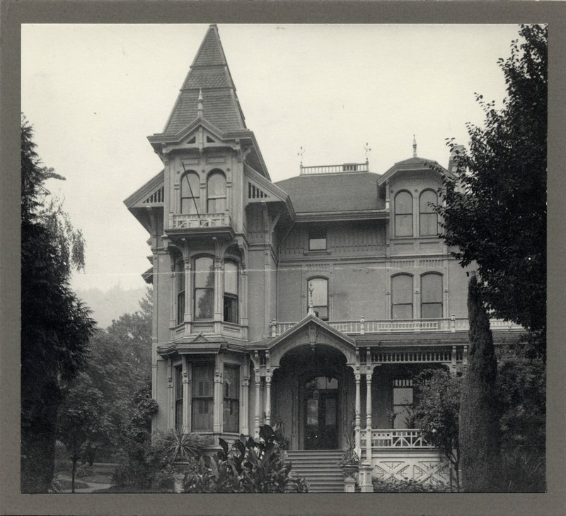 Black and white photograph of Multnomah County Hospital, Hooker Street site, Portland, Oregon, depicting a three-story Victorian building framed by trees.