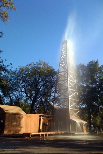 Water shooting out of the top of an oil well. 