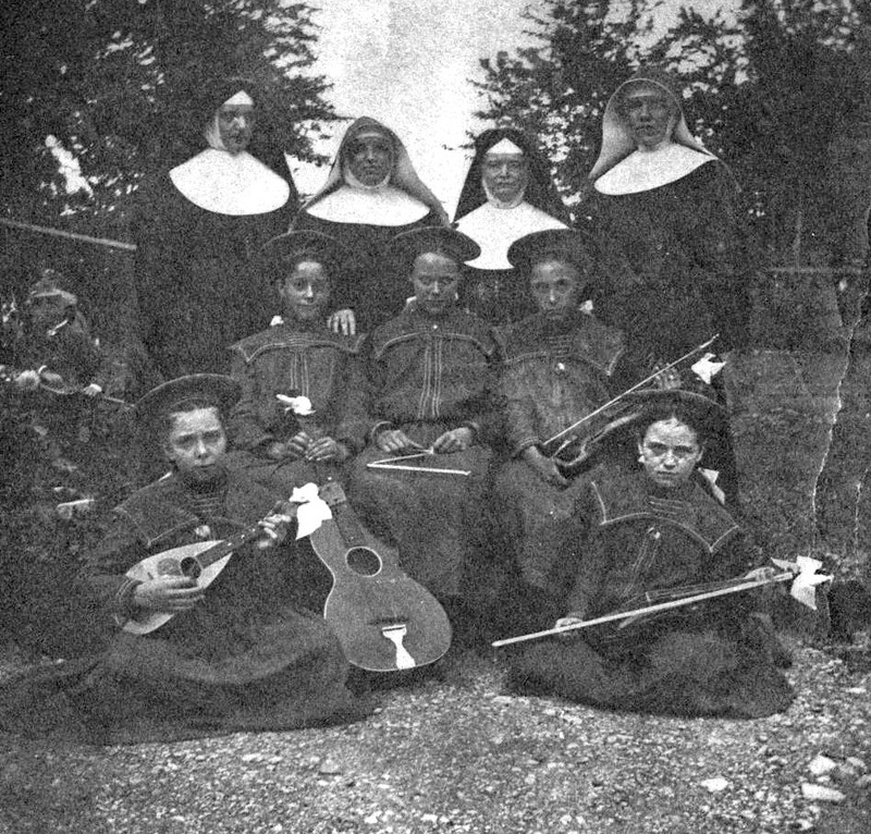 Mother Agnes Hazotte, Sister Ambrose Gross (center), and two visiting sisters with some music students, 1890s.